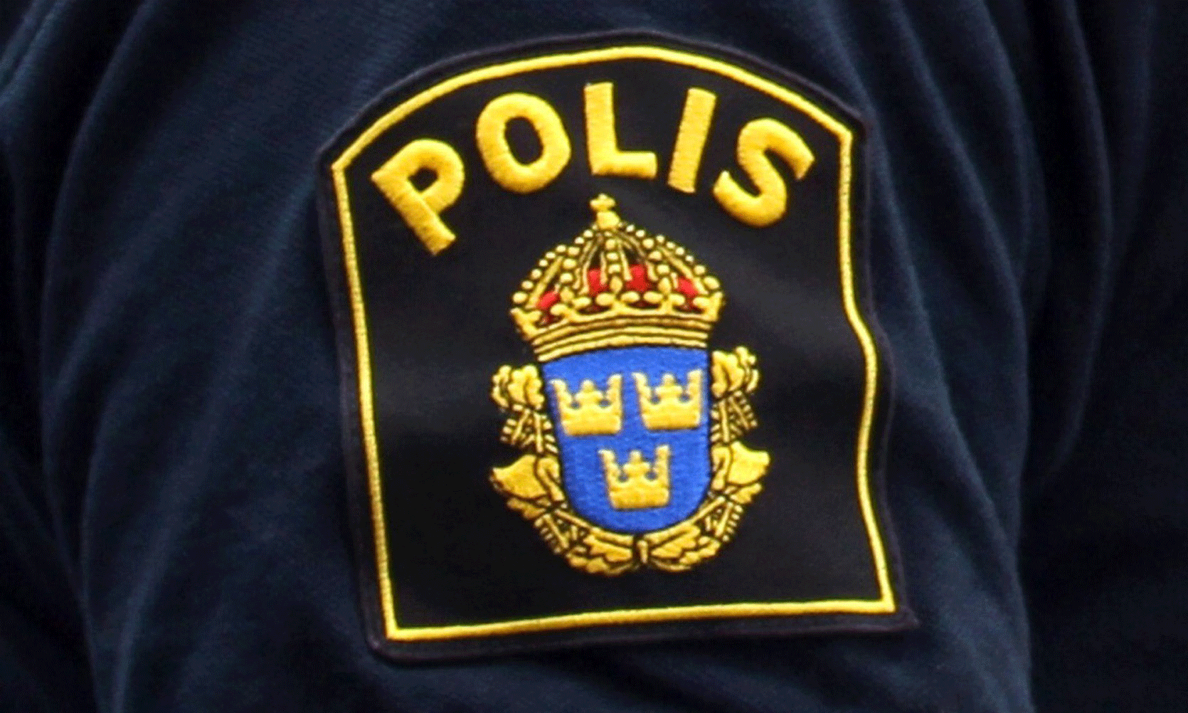 Emblem som det står Polis på