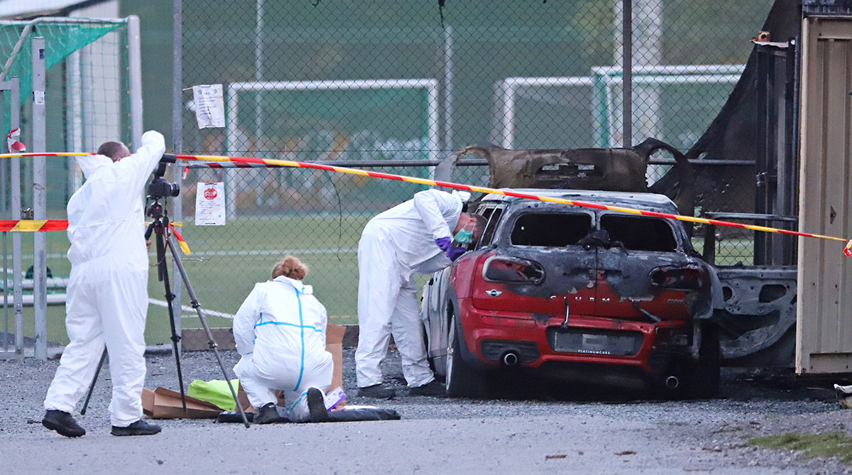 Rickard Friedman fotograferar samtidigt som hans kolleger undersöker brottsplatsen, en utbränd bil, efter ett misstänkt mord i Viksjö.