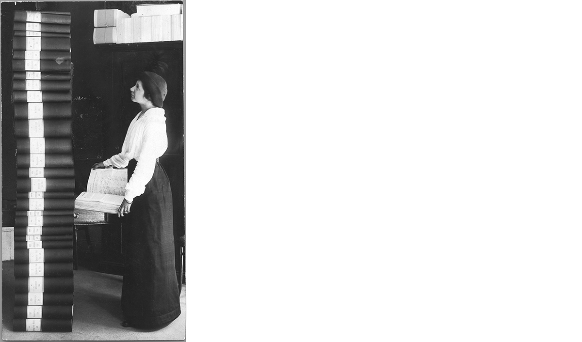 Författaren och rösträttskvinnan Elin Wägner betraktar resultatet av namninsamlingen för kvinnlig rösträtt 1913–1914. Omkring 360 000 namnunderskrifter samlades in.  Reproduktion: KvinnSam, Göteborgs universitetsbibliotek