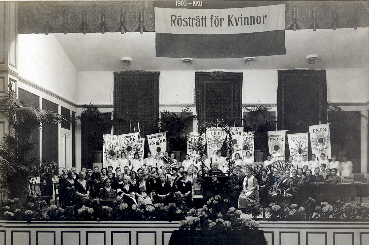 När rösträttskampen slutligen vunnits höll Landsföreningen för kvinnans politiska rösträtt ett möte på Musikaliska akademien i Stockholm 1921 för att fira rösträttssegern. I talarstolen står Ellen Key. Reproduktion: KvinnSam, Göteborgs universitetsbibliotek