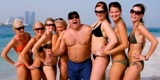 Ambassadrådet Klas Ljungberg på en strand i Abu Dhabi, omgiven av flygvärdinnor – en av de bilder som drivit fram diskussioner kring UDs etik. Foto: Jan Rus/SVT
