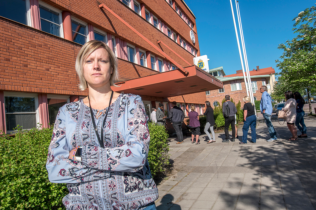 När passhandläggaren Rebecka Brodin öppnar expeditionen på morgonen köar redan många människor utanför. Själv har hon fått både fysiska och psykiska problem av arbetstakten. » Jag har tänkt att jag inte borde kämpa på, men har gjort det ändå«, säger hon.