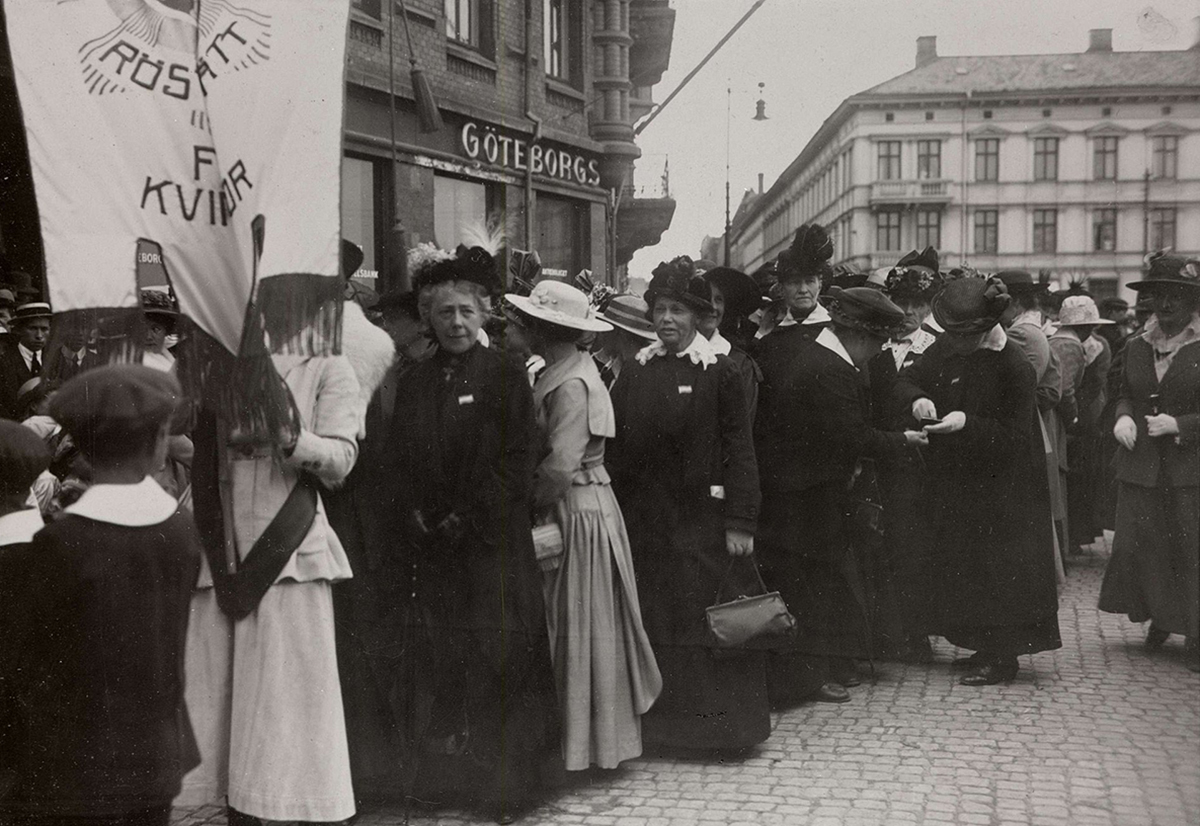 Landsföreningen för kvinnans politiska rösträtt, LKPR, demonstrerar i Göteborg i juni 1918. Initiativtagare var Frigga Carlberg, till höger om fanan.